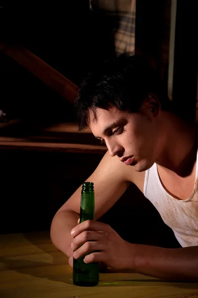 Depressed young man with beer bottle — Stock Photo, Image