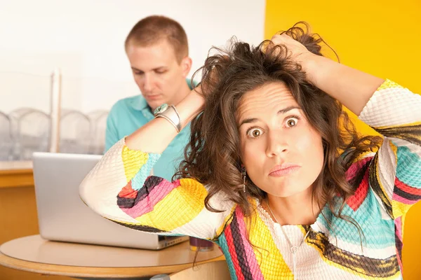 Kadın erkek arkadaşı bir dizüstü bilgisayarda çalışsa da hayal kırıklığı içinde — Stok fotoğraf