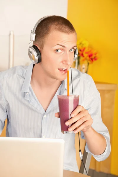 Bir dizüstü bilgisayar kullanarak bir genç adam — Stok fotoğraf