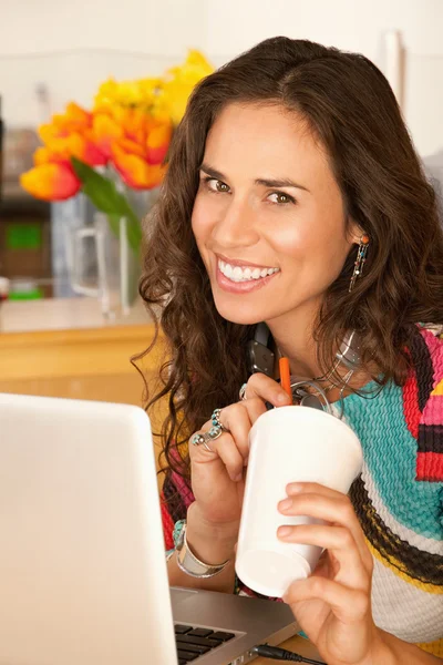 En kvinna sitter vid ett skrivbord med en bärbar dator — Stockfoto