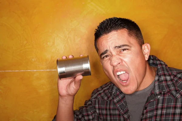 Hispánský muž s plechovkový telefon — Stock fotografie