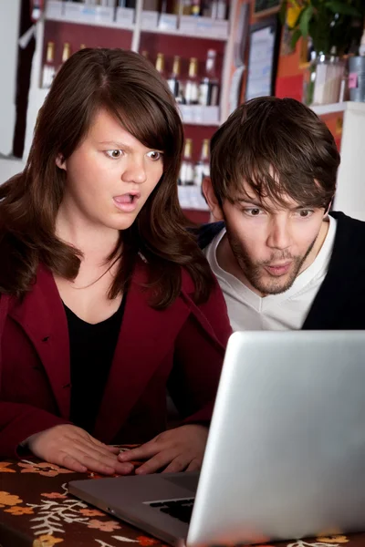 Mujer y hombre mirando con sorpresa a la computadora portátil — Foto de Stock