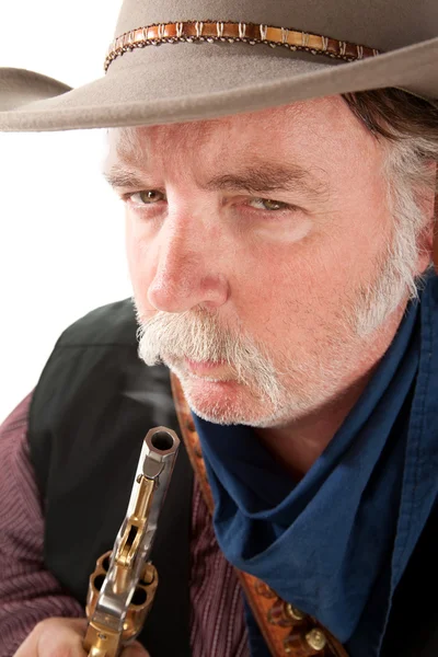 Cowboy blowing on the end of a hot pistol — Stock Photo, Image