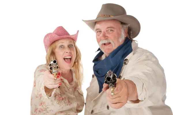 Casal no desgaste ocidental apontando pistolas — Fotografia de Stock