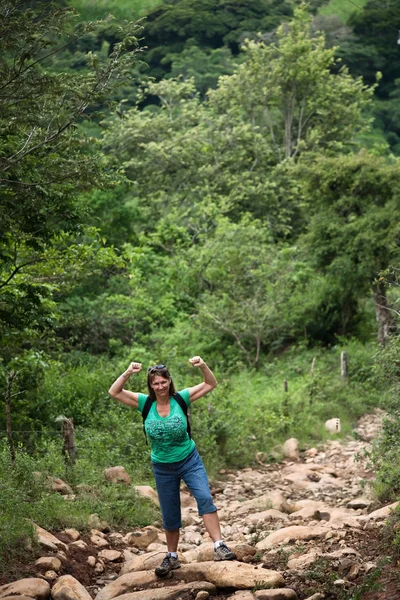 Kvinnliga vandrare böjning på en robust rustikt spår i costa rica — Stockfoto