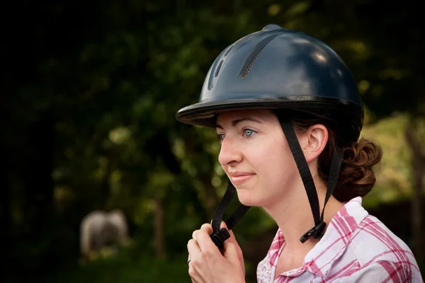 Costa Rican tourist putting on equestrian helmet — Stock Photo, Image