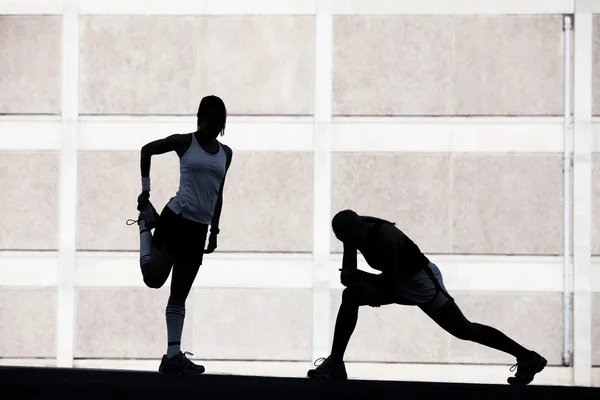 Two women stretching before running. — Stock Photo, Image