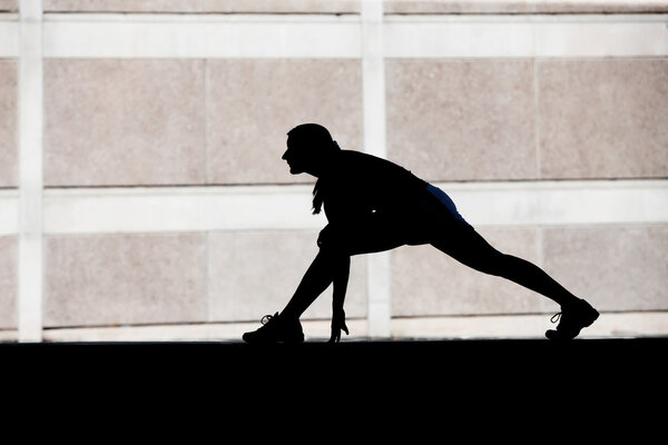Female runner stretches in the morning.