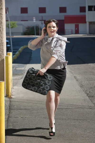 Arbetande kvinna löper längs gatan. — Stockfoto