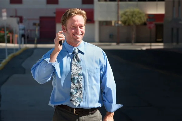 Pleased, good-looking guy talks on cell phone. — Stock Photo, Image