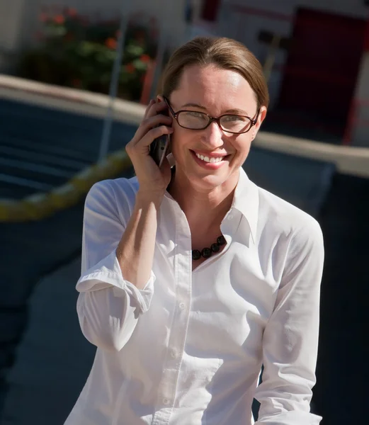 Beautiful woman smiles as she talks on cell phone. — Stock Photo, Image