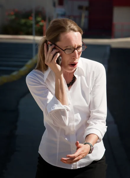 Shocked and amazed woman talks on cell phone — Stock Photo, Image