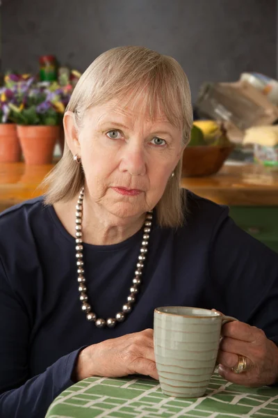 Depressed senior woman with mug — Stock Photo, Image