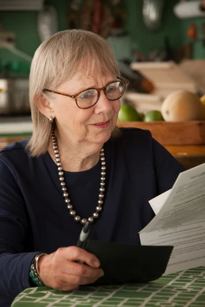 Senior vrouw met vele rekeningen — Stockfoto