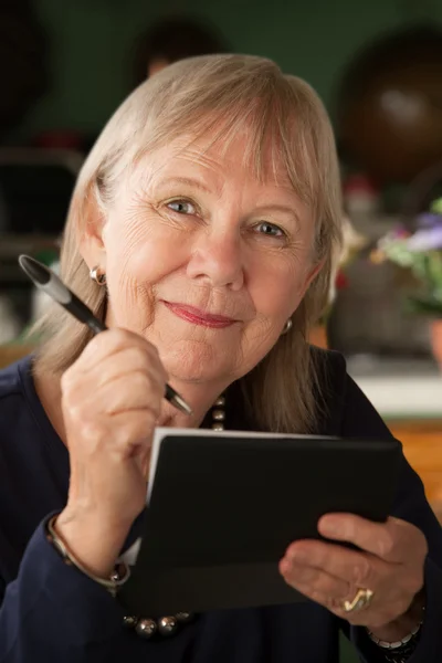 Senior vrouw met chequeboek — Stockfoto