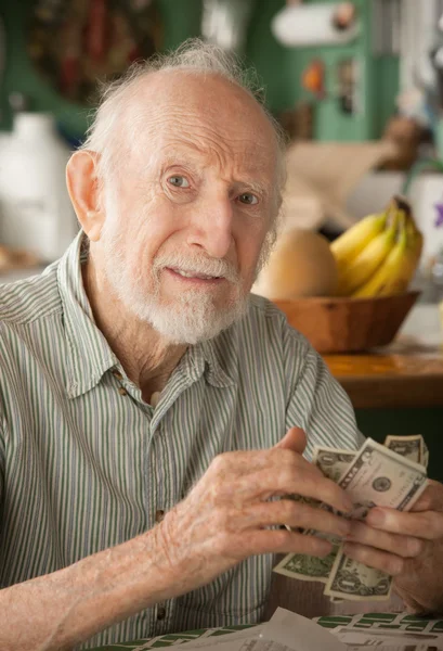 Senior man thuis tellen geld — Stockfoto