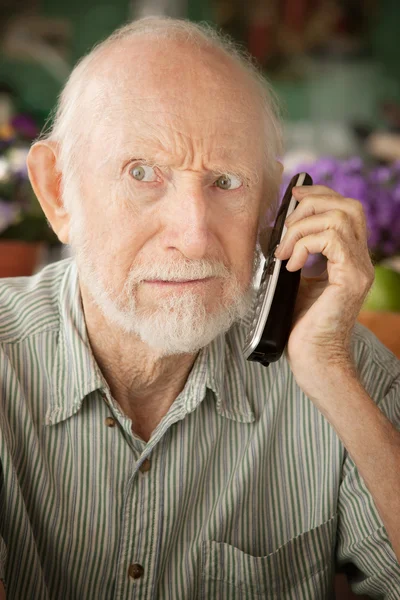 Chagrijnig senior man op telefoon — Stockfoto