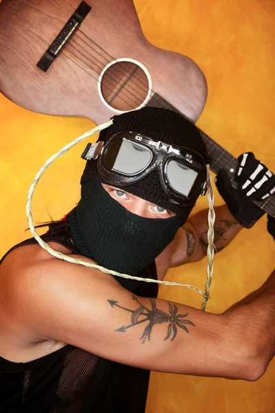 Oddly dressed man swinging guitar — Stock Photo, Image