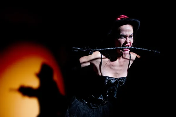 Lady in black carries whip — Stock Photo, Image