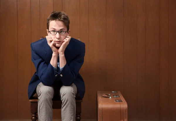 Young Man on Chair with Suitcase — Stock Photo, Image