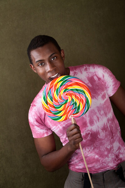Young Man Bites Into a Giant Lollipop