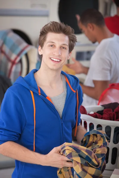 Hombre sonriente en la lavandería —  Fotos de Stock