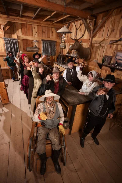 Customers in Old Saloon Toasting Drinks — Stock Photo, Image