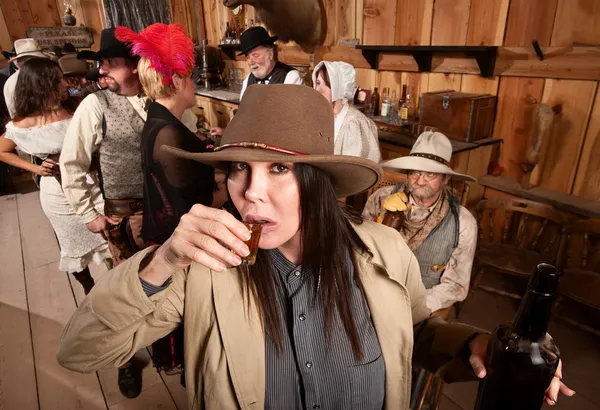 Cowgirl sorseggia whisky nella taverna — Foto Stock