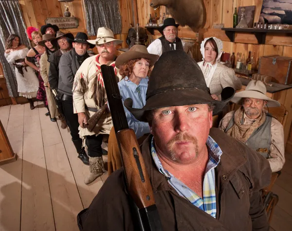 Schwerer Cowboy mit Gewehr in Saloon — Stockfoto