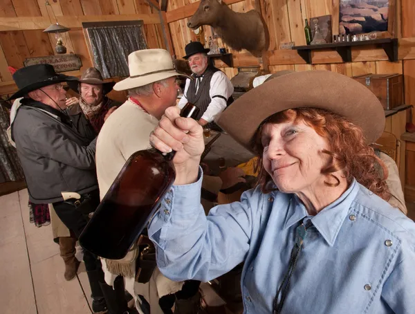 Happy senior cowgirl med flaska — Stockfoto
