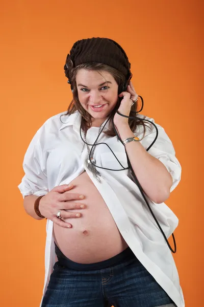 Mujer embarazada escuchando música — Foto de Stock