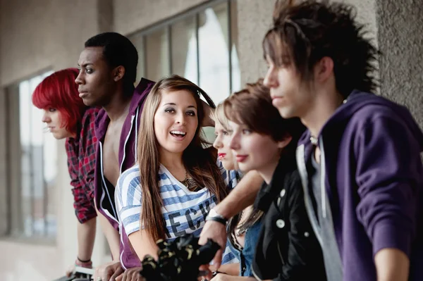 Sorridente punk ragazza guarda la fotocamera e posa come i suoi amici l — Foto Stock