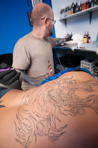 Tattoo kunstenaar grijpt papieren zakdoekje — Stockfoto