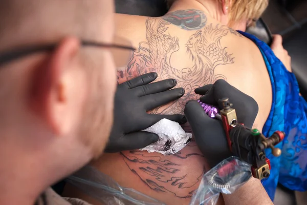 Татуировщик рисует на коже — стоковое фото
