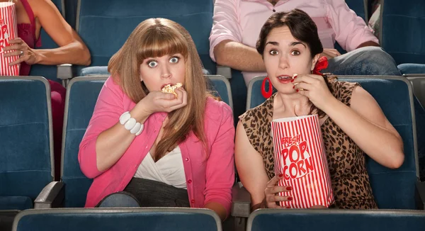 Verblüffte Frauen, die Popcorn essen — Stockfoto