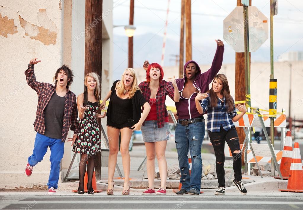 A group of young angry punk rock teens shout across the street.