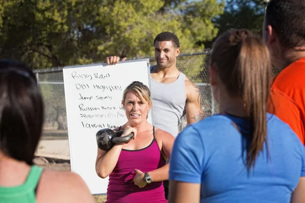 Mujer explicando ejercicios a una clase — Foto de Stock