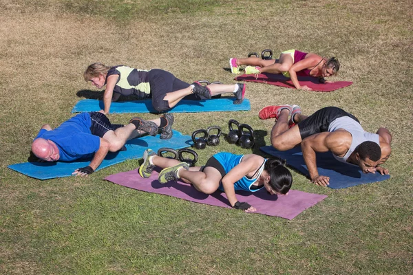 Groupe faisant des exercices de coude de genou — Photo