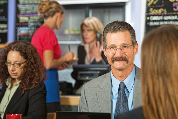 Empresario sentado en la cafetería — Foto de Stock