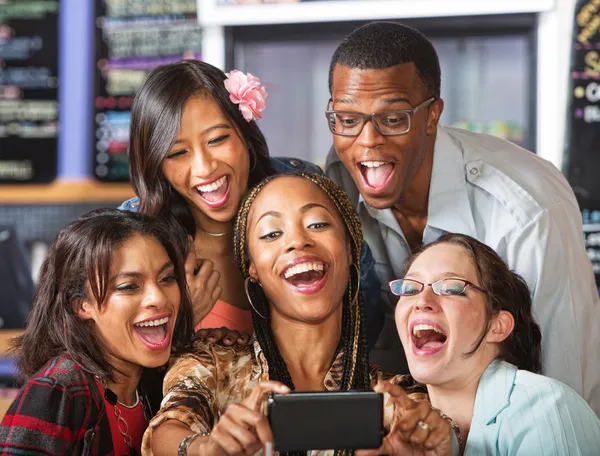 Estudantes rindo segurando Smartphone — Fotografia de Stock