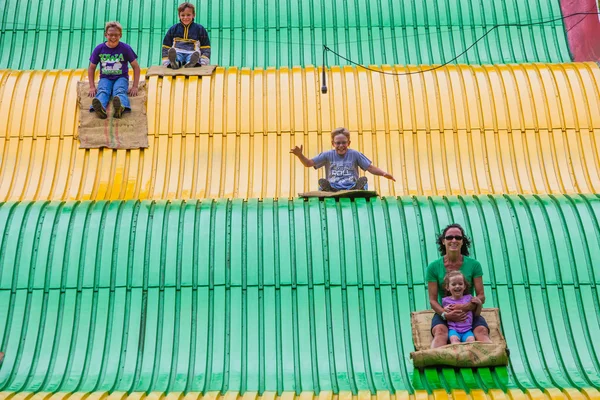 Les gens sur la glissière de carnaval à la foire d'état — Photo