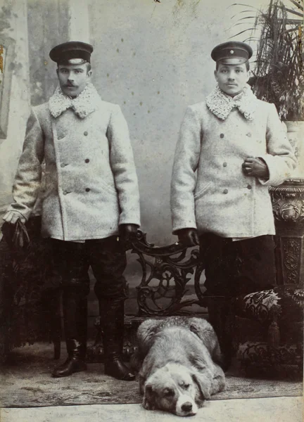 РОССИЙСКИЙ ЭМПИР - CIRCA 1910: Винтажное фото двух молодых людей железнодорожников и собак . — стоковое фото