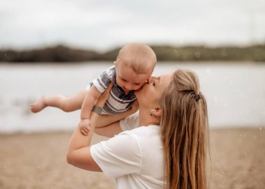 Anne kucağına alıp oğlunu öpüyor.