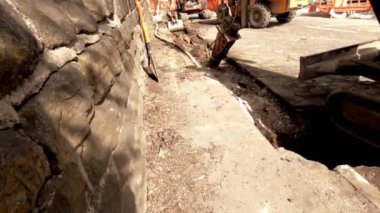 Perküsyon çekici olan kazıcı asfalt kırıyor ve yol çalışması sırasında eski kaldırımları kaldırıyor