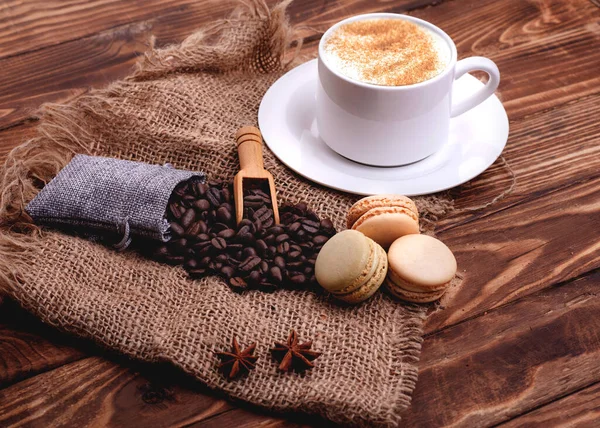 木製の背景にコーヒー豆シナモンマカロン — ストック写真