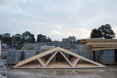 Kereste kirişleri ve beton bloklar yeni konut geliştirme şantiyesine teslim edildi ve açık alanda depolandı