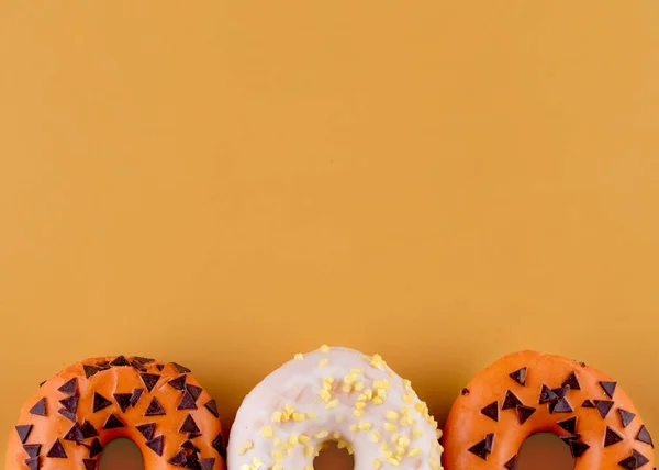 Два Апельсинових Пончика Один Білий Помаранчевому Фоні — стокове фото