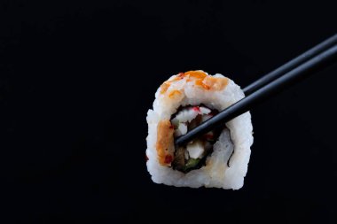 Siyah arka planda çubukları olan suşi.