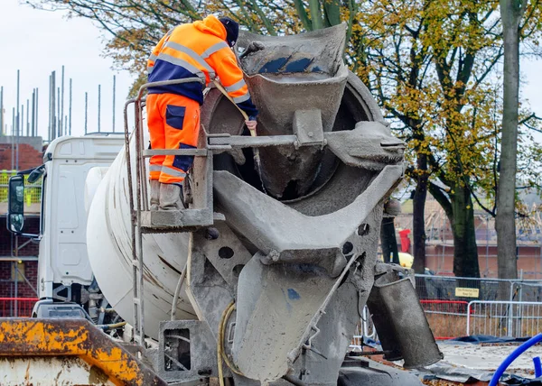 İnşaat alanında beton teslimatı yaptıktan sonra teslimatçı vagonu yıkıyor.