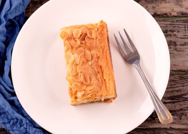 Kafedeki tahta masada beyaz tabakta kek.